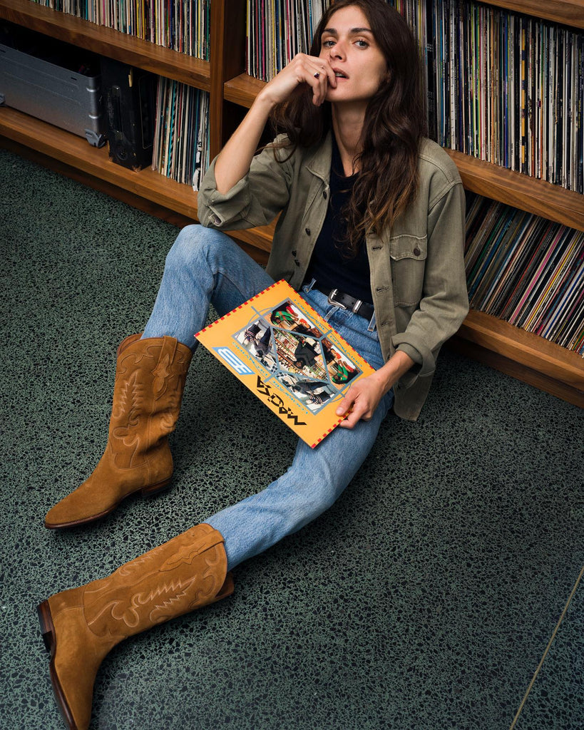 Elisa Sednaoui avec des western boots couleur ambre. Bottes santiags couleur ambre avec un disque à la main